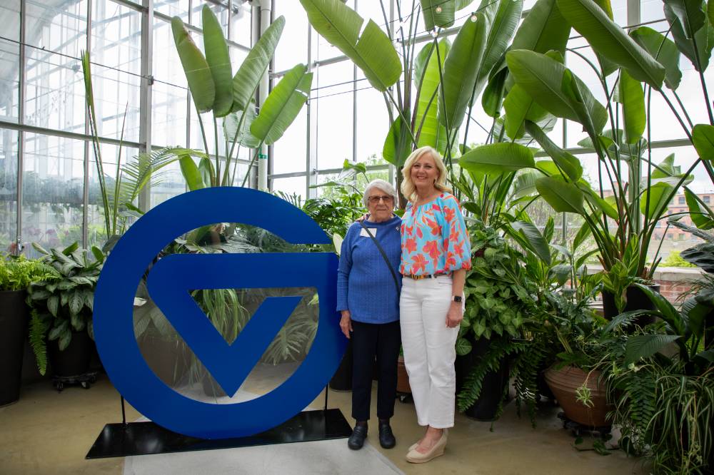 Two party attendees standing by circle G